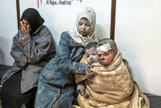 A Syrian woman sits with injured children at a hospital following a reported strike by government forces in the rebel-held district of Barzah, on the northeastern outskirts of the capital Damascus on Monday (AFP photo)