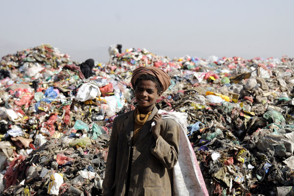 Yemeni people collect garbages form piles of rubbish for recycling at the garbage dump in Sanaa, Yemen, on Saturday (Anadolu Agency photo)