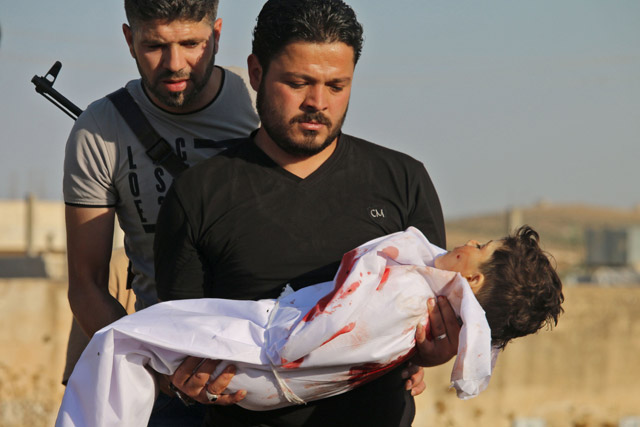 A Syrian father carries the body of his four-year-old son who was reportedly killed during shelling by Syrian government forces on a rebel-held area in the southern Syrian city of Daraa, on Monday (AFP photo)