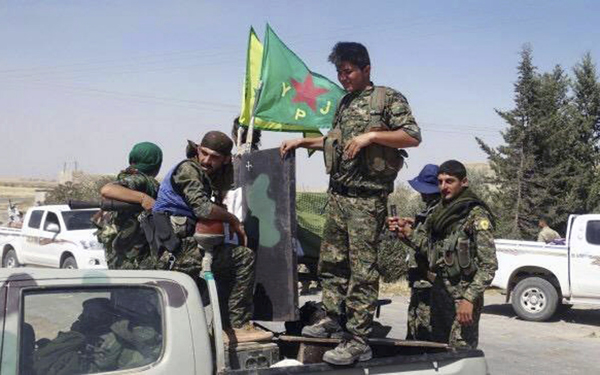 In this file photo released on June 23, 2015, provided by the Kurdish fighters of the People’s Protection Units, which has been authenticated based on its contents and other AP reporting, Kurdish fighters of the YPG, sit on their pickup in the town of Ein Eissa, north of Raqqa city, Syria (AP photo)