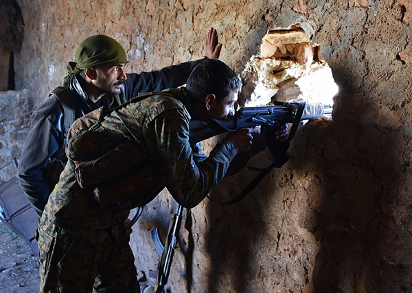 A fighter from the Syrian pro-government forces mans a riffle inside a damaged house in the recently recaptured village of Joubah during an offensive towards the area of Al Bab in Aleppo province on Friday (AFP photo)