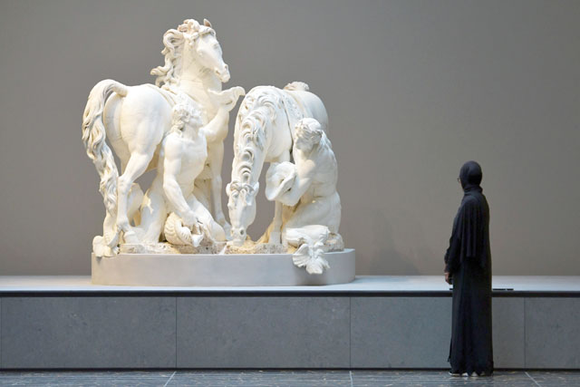 A woman looks at a statue titled ‘Horses of the Sun’ by French sculptor Gilles Guerin at the Louvre Abu Dhabi Museum during a media tour on Monday prior to the official opening of the museum on Saadiyat Island in the Emirati capital on Wednesday (AFP photo)