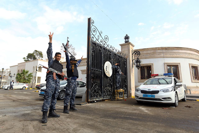 Libyan security forces flash the V-sign of victory outside the Guest Palace, a complex of luxury villas in the city centre, in the capital Tripoli, following exchanges of rocket and artillery fire between unity government forces and a militia loyal to a former prime minister on Wednesday (AFP photo)