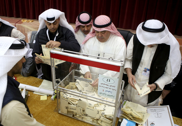 A Kuwaiti judge (centre) and his aides count the ballots at a polling station at the end of the vote in the Sabah Al Salem district on the outskirts of Kuwait city on Saturday (AFP photo)