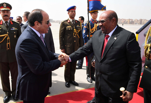 Egyptian President Abdel Fattah Al Sisi shakes hands with Sudan’s President Omar Al Bashir at Cairo’s airport, Egypt, on Monday (Reuters photo)
