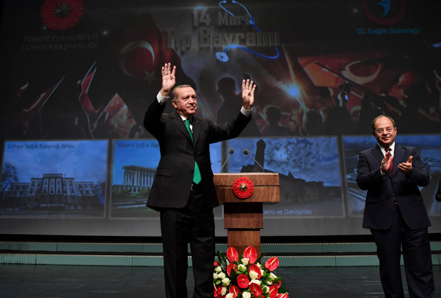 Turkish President Recep Tayyip Erdogan, accompanied by Health Minister Recep Akdag, greets the audience during a meeting in Ankara, Turkey, on Tuesday (Reuters photo)
