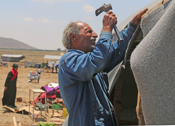 A displaced Syrian man from Daraa hammers in a makeshift camp in Quneitra, southwestern Syria, near the border with Israel, on Sunday (AFP photo)