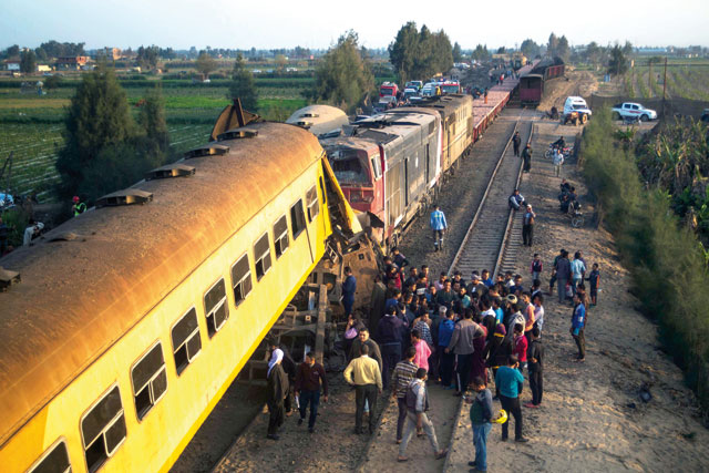 Egyptians check the damage following a train crash in Egypt’s northern Beheira province on Wednesday. At least 12 people were killed and 15 wounded when two trains collided (AFP photo)