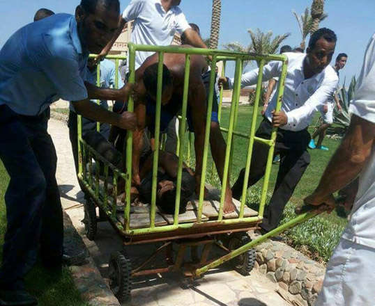 Workers and security detain the man who stabbed two German tourists to death and wounded four others during an attack of the Zahabia hotel resort in Hurghada, south of the capital Cairo, Egypt, on Friday (Reuters photo)