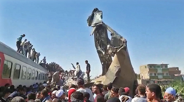 This screengrab provided by AFPTV shows people gathered around the wreckage of two trains that collided in the Tahta district of Sohag province, some 460 km south of the Egyptian capital Cairo, on Friday (AFP photo)