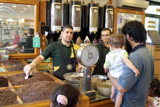A vendor weighs roasted coffee beans at a shop in Amman. Cardamom-flavoured Arabic coffee is a fixture drink during Eid in Jordan (Photo by Hassan Tamimi)