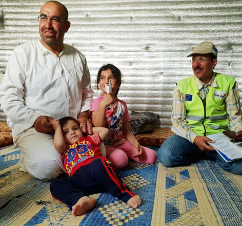 Khalid and his children pose for a photo with Mahmoud, one of the community mobiliser volunteers, inside Azraq refugee camp recently  (Photo courtesy of World Vision)