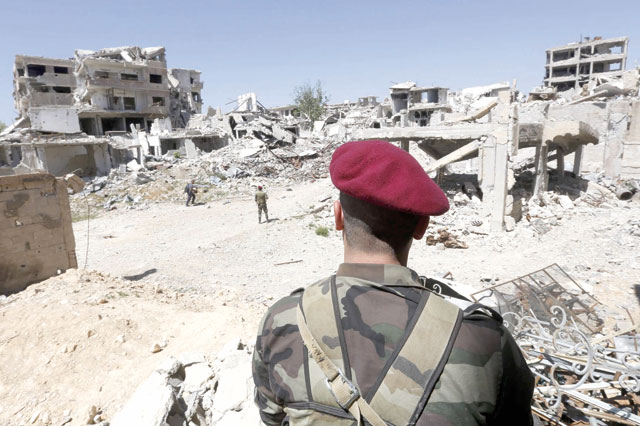 Syrian regime troops are seen walking amid the destruction in the previously rebel-held Jobar in Eastern Ghouta on Monday (AFP photo)