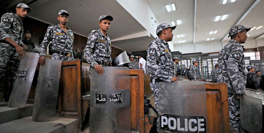 Police stand guard during a court session in which 739 people are being tried for participating in a 2013 sit-in in support of the Muslim Brotherhood in Cairo, Egypt, on Saturday (Reuters photo)