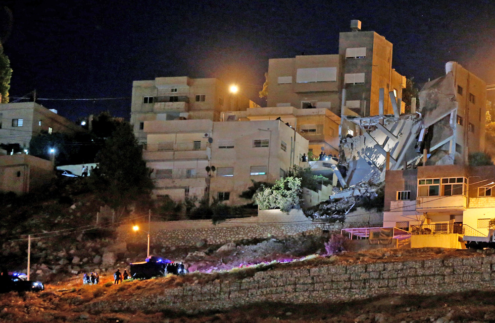 Security forces are seen near a damaged building after the security operation in the city of Salt on Saturday (Reuters photo)