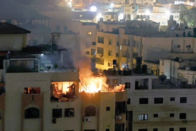 A fire breaks out at an apartment following an explosion in Gaza City, on Tuesday. Thirteen people were killed Tuesday before dawn in Israeli air strikes on the Gaza Strip (AFP photo)