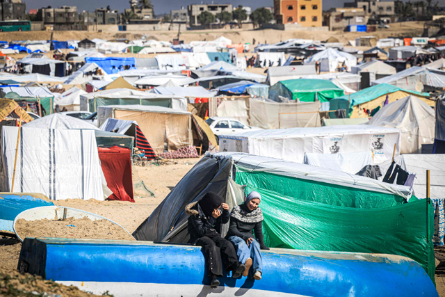 Children sit near tents at a make-shift shelter for Palestinians who fled to Rafah in the southern Gaza Strip on Tuesday amid the ongoing Israeli offensive against the besieged enclave (AFP photo)
