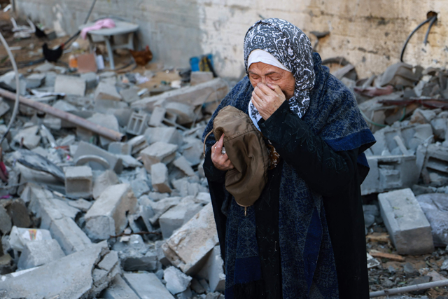 A woman reacts as she salvages belongings from the rubble of a destroyed house following Israeli bombardment in Rafah in the southern Gaza Strip on Saturday (AFP photo)