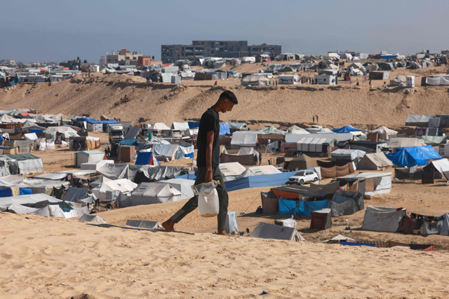 A Palestinian man ferries water at a makeshift camp for displaced people in Rafah in the southern Gaza Strip on Thursday, amid the Israeli offensive against the besieged costal enclave (AFP photo)