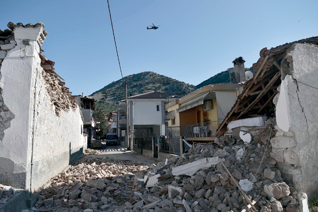 An army helicopter flies over collapsed buildings in the village of Damasi, near the town of Tyrnavos, after a strong 6,3-magnitude earthquake hit the Greek central region of Thessaly on March 3, 2021 (AFP photo)