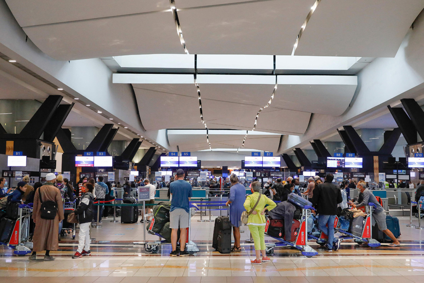 Travellers queue at a check-in counter at OR Tambo International Airport in Johannesburg on Saturday, after several countries banned flights from South Africa following the discovery of a new COVID-19 variant Omicron (AFP photo)