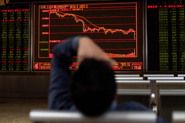 An investor gestures as he looks at stock price movements on a screen at a securities company in Beijing on Friday. Asia’s main stock markets traded lower, but losses were relatively muted as investors took a breather after a global rout (AFP photo)