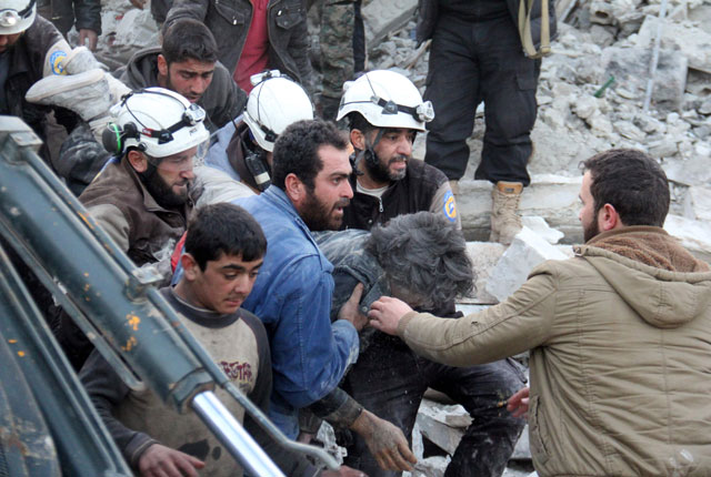 Syrian civil defence volunteers carry a wounded man following a reported air strike by government forces in the Syrian town of Binnish, on the outskirts of Idlib, on Thursday (AFP photo)