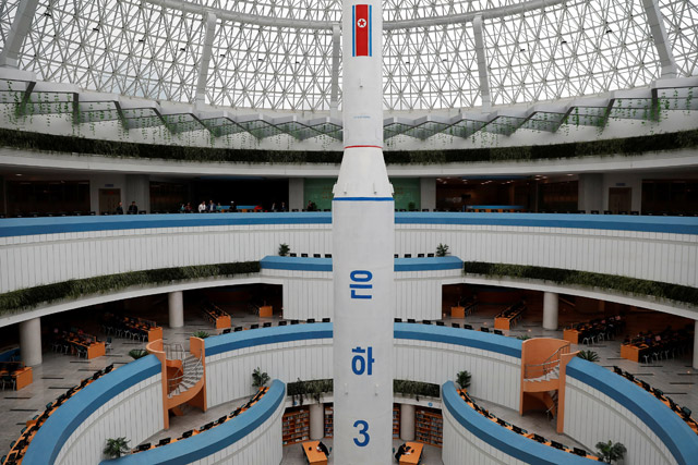 Students read under a replica of Unha-3 rocket displayed at the Sci-Tech Complex in Pyongyang, North Korea, on Monday (Reuters photo)