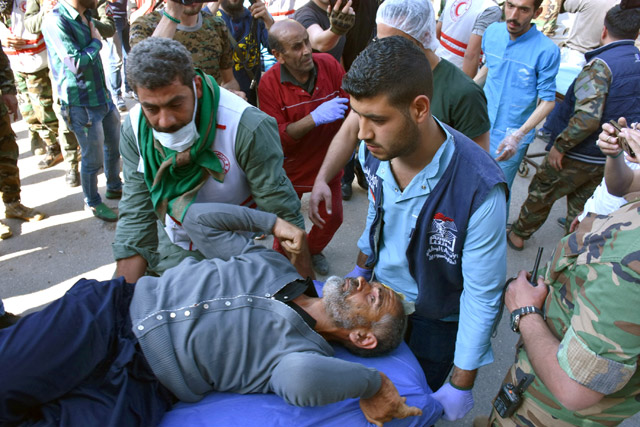 Men carry a stretcher of one of the evacuees from the two rebel-besieged Shiite villages of Al Foua and Kefraya, upon his arrival to government-controlled Aleppo, in this handout photo provided by SANA on Wednesday (Reuters photo)