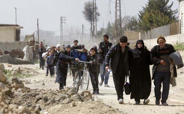 Civilians evacuated from the Eastern Ghouta enclave pass with belongings on March 15 (AFP photo)