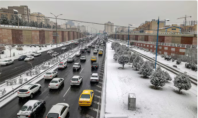 Amid heavy snowfall, vehicles were seen driving along the park in Tehran (AFP photo)