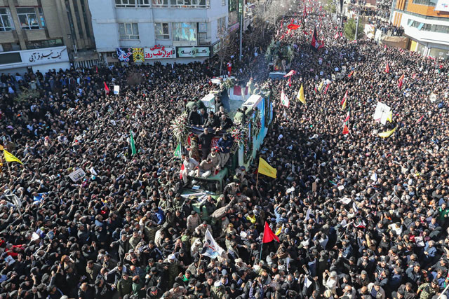 Iranian mourners gather around a vehicle carrying the coffin of slain top general Qasem Soleimani during the final stage of funeral processions, in his hometown Kerman, on Tuesday (AFP photo)