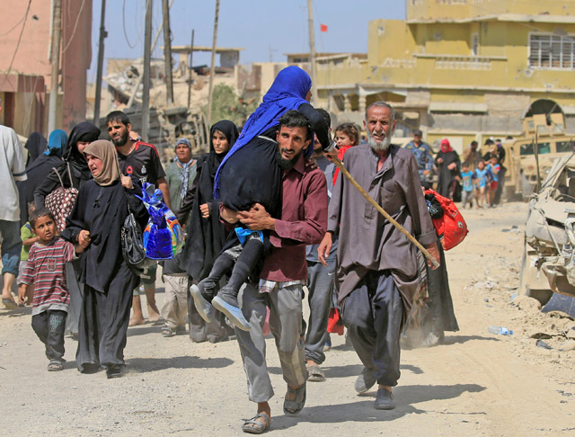 A displaced Iraqi man who fled from clashes carries a woman in western Mosul, Iraq, on Saturday (Reuters photo)
