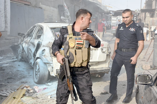 Police officers take security measures after a suicide bomber detonated his explosive vest in Atlas street in Kirkuk, Iraq Sunday  (Anadolu Agency photo)