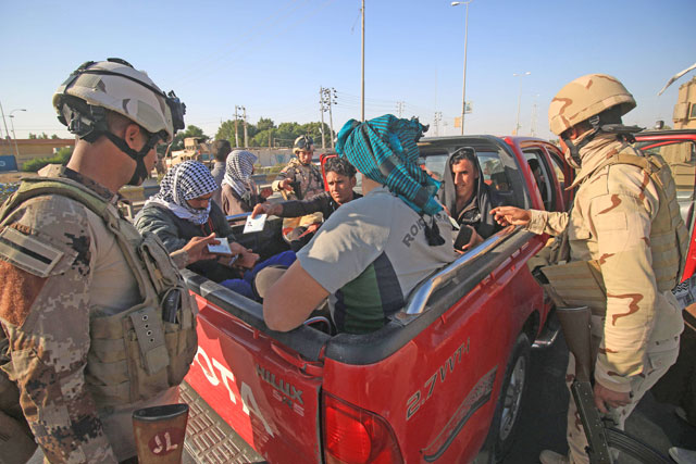 Iraqi soldiers check the documents of passengers as they control one of several checkpoints they set up along the main 50-kilometre road between the area of Karmat Ali on the northern outskirts of Basra and the town of Al Dayr on January 13 (AFP photo)
