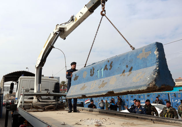 Iraqi security forces remove a concrete barrier in Baghdad, Iraq, on Tuesday. Iraqi authorities say they have started removing some of the security checkpoints in Baghdad in a bid to ease traffic in the country’s capital (AP photo) 