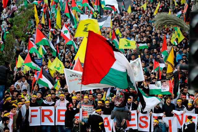 Supporters of Lebanon’s Hizbollah Shiite movement wave national Palestinian (front) and Hizbollah’s yellow flags during a massive rally in the Lebanese capital Beirut on Monday to protest US President Donald Trump’s controversial recognition of Jerusalem as Israel’s capital (AFP photo)