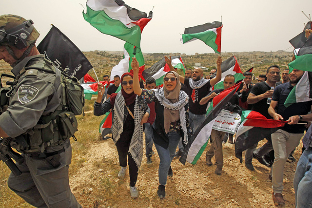 Palestinians rally near the separation fence between occupied Jerusalem and Bethlehem, ahead of commemorations marking the 70th anniversary of the Nakba, on Thursday (AFP photo)