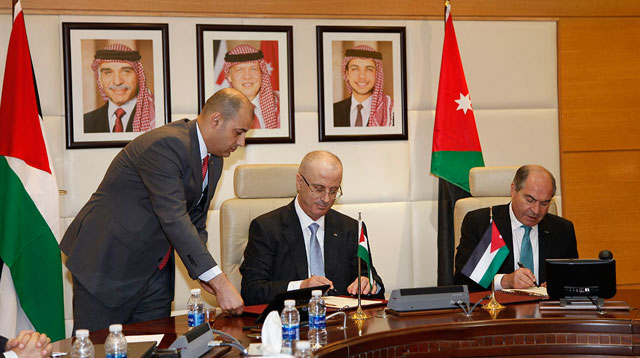 Prime Minister Hani Mulki (right) and his Palestinian counterpart Rami Hamdallah (2nd left) sign a deal at the conclusion of a Jordanian-Palestinian joint committee meeting in Amman on Wednesday (Petra photo)