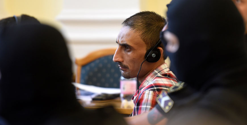 The Afghan leader of four human traffickers who were sentenced to 25 years in prison for letting 71 migrants suffocate inside a truck in 2015, listens to the judge as he announces the verdict and reasoning in a Hungarian court in Kecskemet, Hungary, on Thursday (Reuters photo)