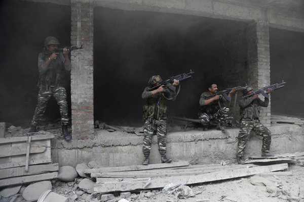 Indian paramilitary soldiers take positions near the site of a gun battle in the Nowhatta neighbourhood of Srinagar in Indian controlled Kashmir on August 15 (AP photo)