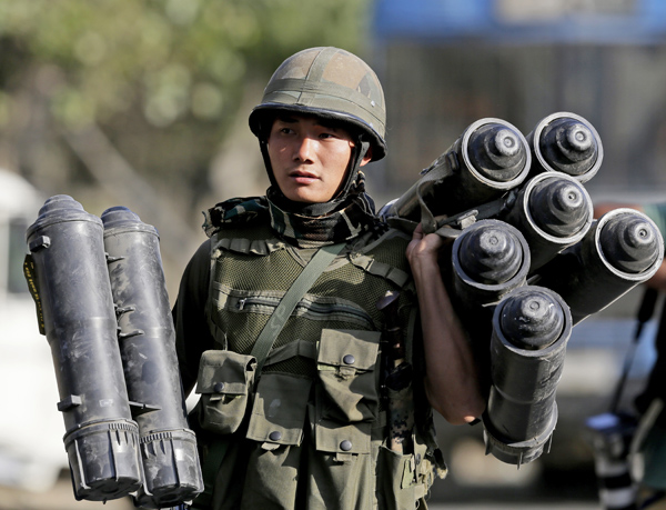 An Indian Army soldier carries used ammunition boxes outside the government building where suspected militants had taken refuge during a gun battle in Pampore, on the outskirts of Srinagar, Indian controlled Kashmir, on Wednesday (AP photo)