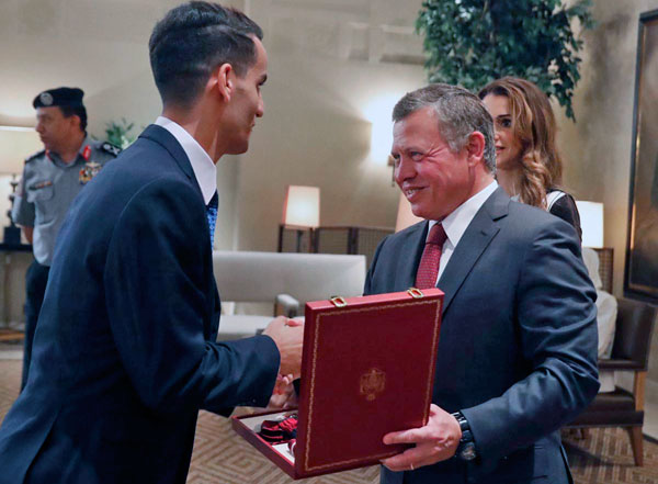 His Majesty King Abdullah presents a medal to taekwondo gold medallist Ahmad Abu Ghaush as he and Her Majesty Queen Rania received and honoured the champion, his coach and the rest of the Rio 2016 Olympic team in Amman on Tuesday  (Photo courtesy of Royal Court)