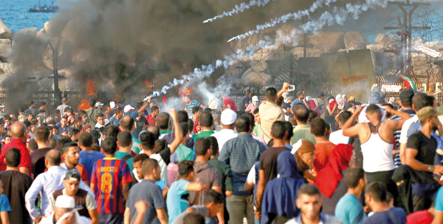 Tear gas canisters are fired by Israeli forces at Palestinians during a protest calling for lifting the Israeli blockade on Gaza, at the maritime border with Israel, in the northern Gaza Strip on Monday (Reuters photo)