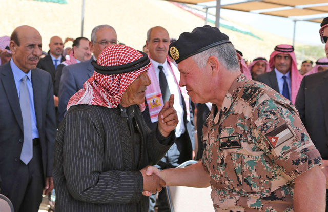 His Majesty King Abdullah listens to a Karameh Battle veteran as he attends a ceremony in Jordan Valley to mark the 50th anniversary of the battle on Sunday (Photo courtesy of Royal Court)