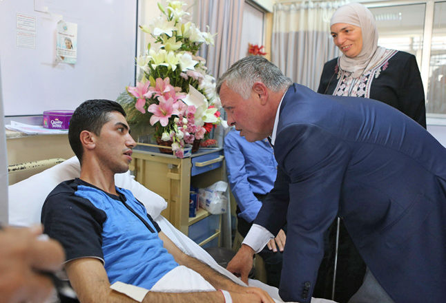 His Majesty King Abdullah checks on a wounded officer injured during a raid targeting suspected terrorists at Al Hussein Medical Centre on Sunday (Photo courtesy of Royal Court)