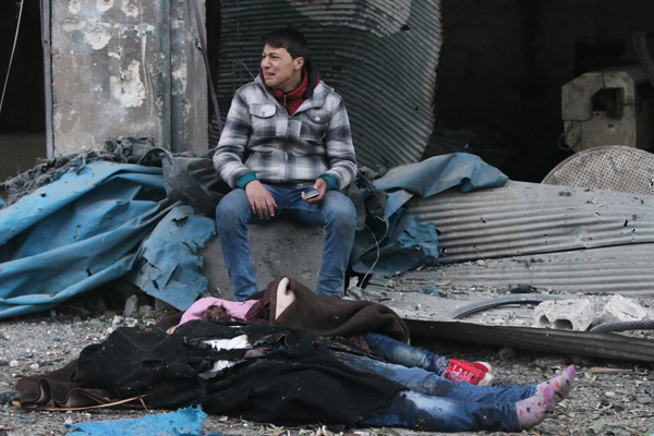 A Syrian man cries near a dead body of a girl after warplanes reportedly belonging to the Assad regime forces carried out air strikes over residential areas at the Jub Al Quba neighbourhood in Aleppo on Wednesday (Anadolu Agency photo)