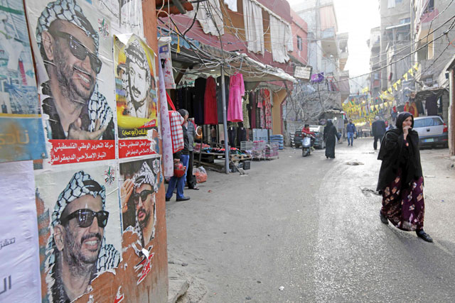 This photo taken on Thursday shows posters of late Palestinian leader Yasser Arafat plastered on a wall as residents walk past them down a street in the Burj Al Barajneh camp, a southern suburb of the Lebanese capital Beirut (AFP photo)