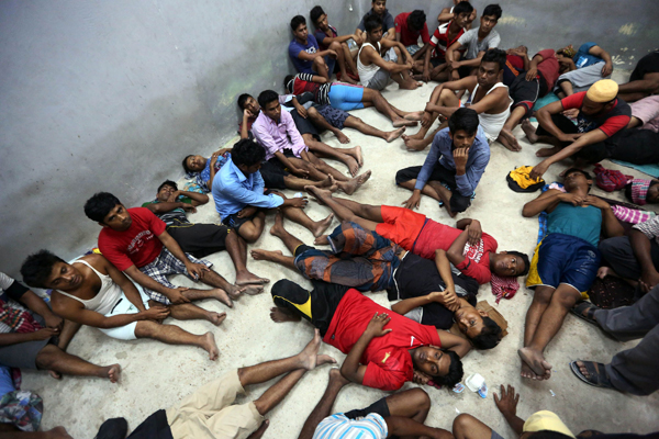 Migrants from Bangladesh rest in a room at the interior ministry's Al Nasr housing centre for illegal immigrants on Wednesday in the port city of Zawiyah, located some 45 kilometres west of the capital Tripoli (AFP photo)