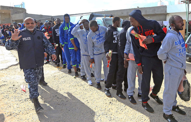 African migrants hold their documents as they gather at a detention centre in the Libyan capital Tripoli on Tuesday ahead of being repatriated to their country of origin under a voluntary programme coordinated by the International Organisation for Migration (AFP photo)